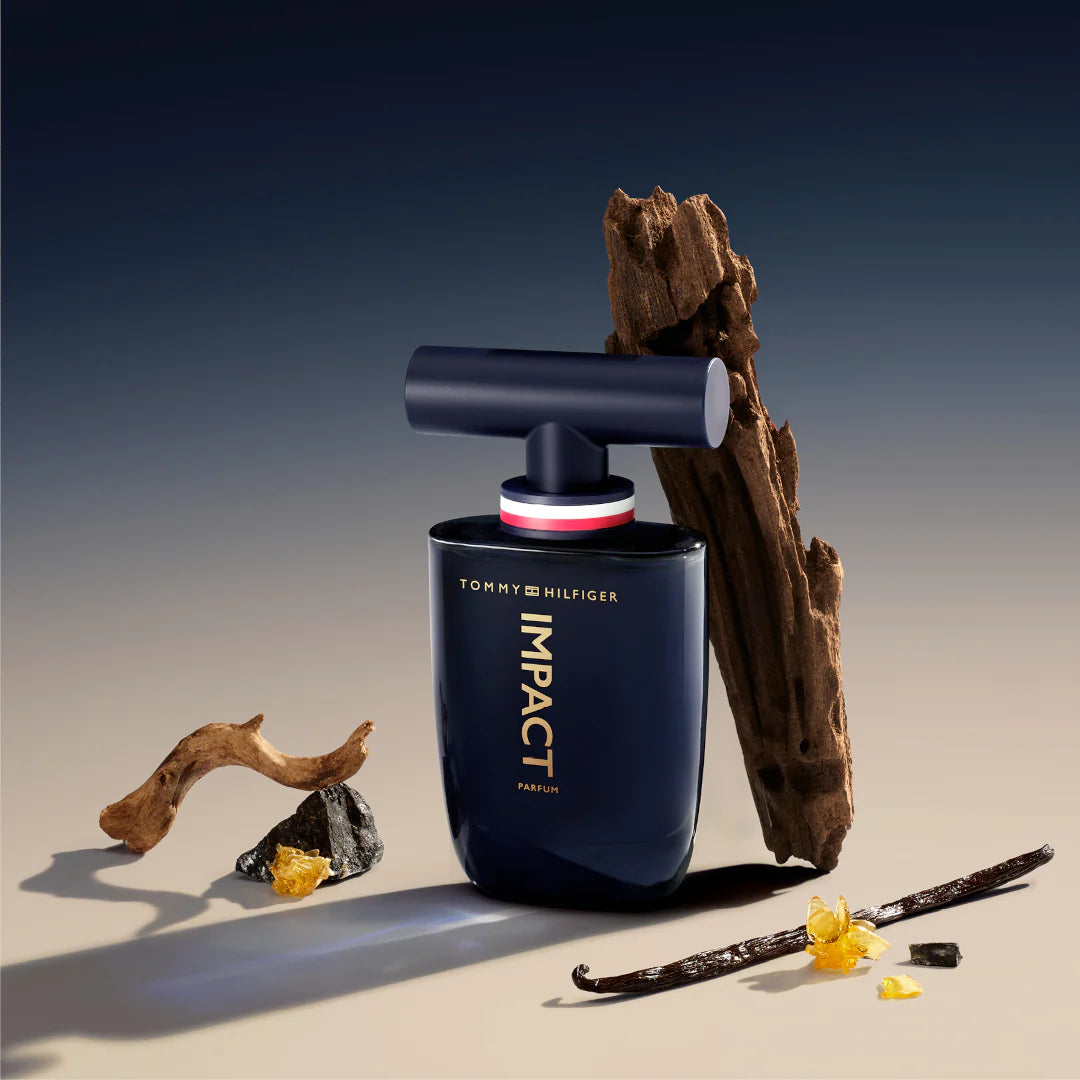 Vista lateral del perfume Impact Parfum Tommy Hilfiger 100ml destacando su botella azul oscuro y tapa plateada