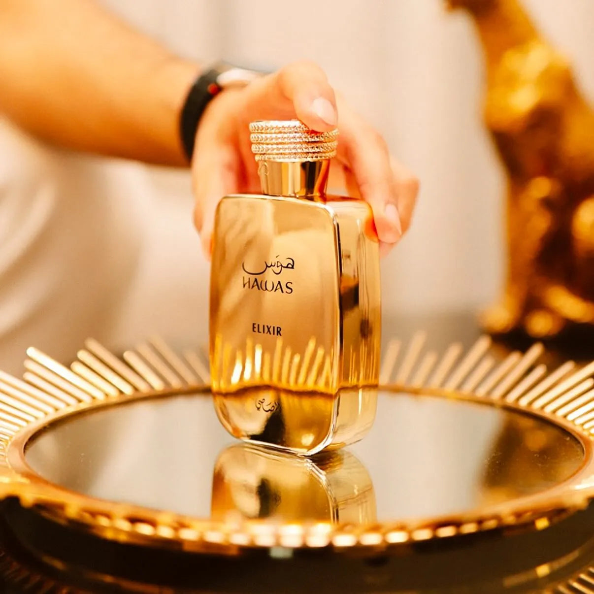 perfume rasasi hawas elixir de 100ml presentación botella dorada vista frontal y lateral con bellos detalles dorado